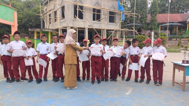 Kepala Sekolah SDN 61 Lekkong Enrekang, Nuraini Ismail Serahkan Sertifikat Juara Kepada Muridnya.